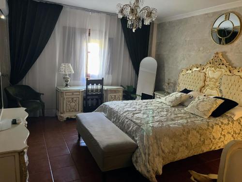 a bedroom with a large bed and a chandelier at Casa de Gaia in Alicante