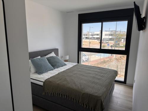 - une chambre avec un lit et une grande fenêtre dans l'établissement MADRESELVA 62.29, à Torre-Pacheco
