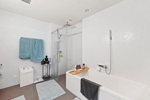 蘇黎世的住宿－Exclusive spacious Apt. with garden in Zurich，白色的浴室设有浴缸和淋浴。