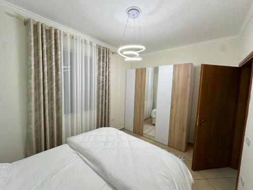 sypialnia z białym łóżkiem i oknem w obiekcie Laert's Appartement w Tiranie