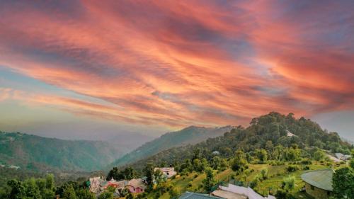 a cloudy sky over a village in the mountains at Aliza Inn And Suites By SRS Hotels in Dharamshala