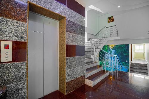 a hallway with a staircase with a mural on the wall at Aliza Inn And Suites By SRS Hotels in Dharamshala