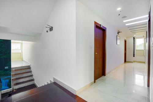 a hallway with a red door and stairs at Aliza Inn And Suites By SRS Hotels in Dharamshala