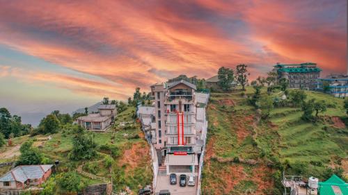 a building on the side of a hill at Aliza Inn And Suites By SRS Hotels in Dharamshala