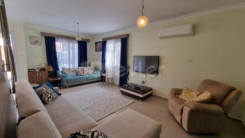 a living room with a couch and a tv at Sunny Pearl of Cyprus in İskele