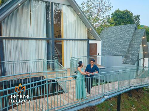 two women standing on the balcony of a house at Serene Horizon in Thekkady