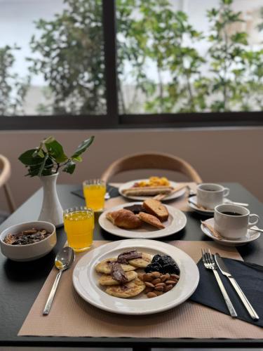 a table with plates of breakfast food on it at Angela Downtown Hotel in Rhodes Town
