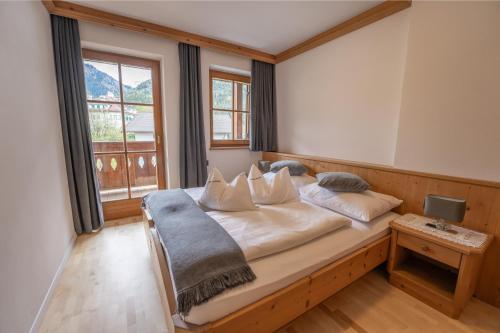 een groot bed in een kamer met een groot raam bij Residence Burghof in Siusi