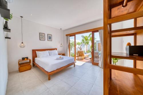 a bedroom with a bed and a sliding glass door at *NEW* Modern 3BD Villa in quiet Perenenan! in Canggu