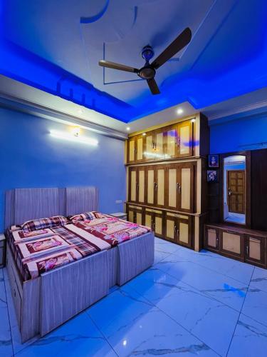une chambre avec un lit et un ventilateur de plafond dans l'établissement Exquisite 3 BHK Furnished House near Har Ki Pauri:, à Haridwar