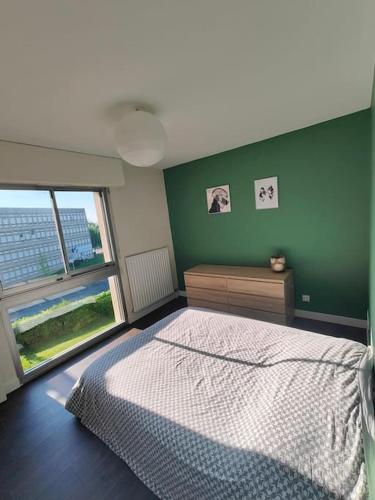 une chambre avec un lit et un mur végétal dans l'établissement Joli appartement avec balcon, à Caen