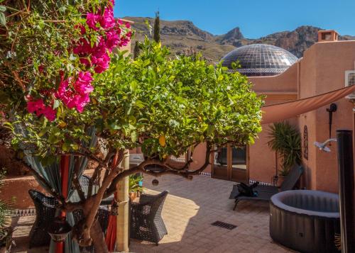 einen Balkon mit einem Baum mit rosa Blumen drauf in der Unterkunft Casa de la Roca - A Beautiful 2 Bed/2 Bath Detached Villa in Almería