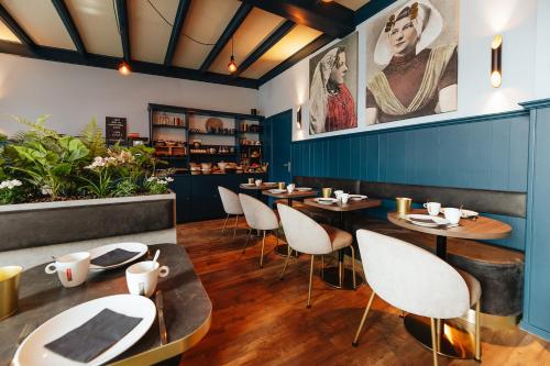 een restaurant met houten tafels en stoelen en blauwe muren bij Hotel Renesse in Renesse