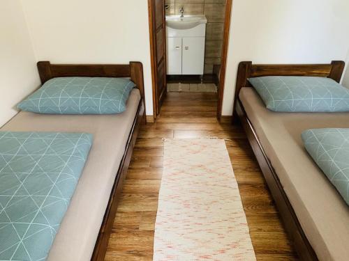 two twin beds in a room with a mirror at Arvisura Vendégházak family friendly transit apartments in Zsombó