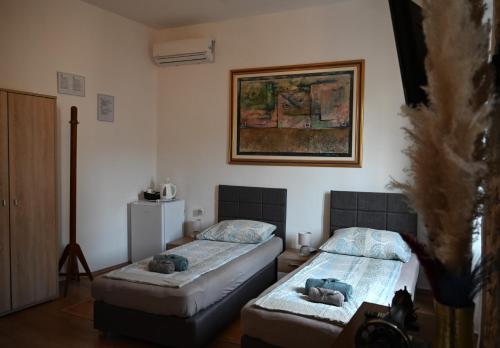 dwa łóżka w pokoju z obrazem na ścianie w obiekcie Ivana Rooms w Puli