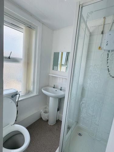 a bathroom with a toilet and a sink and a shower at Burlington West hotel in Blackpool