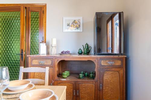 a dining room with a wooden cabinet with a mirror at Cozy house in Priorat! Barbecue & Relax - Climbing & Views in Poboleda