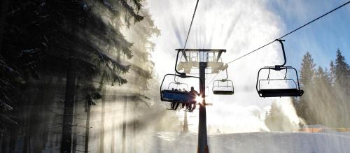 a group of people riding a ski lift in the snow at Apartment Riviera 504-4 Lipno Home in Český Krumlov