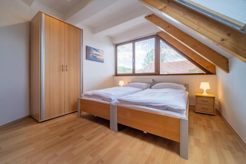a bedroom with a bed and a large window at Apartment Riviera 504-4 Lipno Home in Český Krumlov