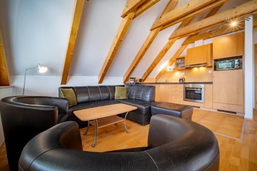 a living room with a leather couch and a table at Apartment Riviera 504-4 Lipno Home in Český Krumlov