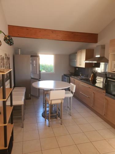 une cuisine avec une table et des chaises dans l'établissement Appartement mer, à Valras-Plage