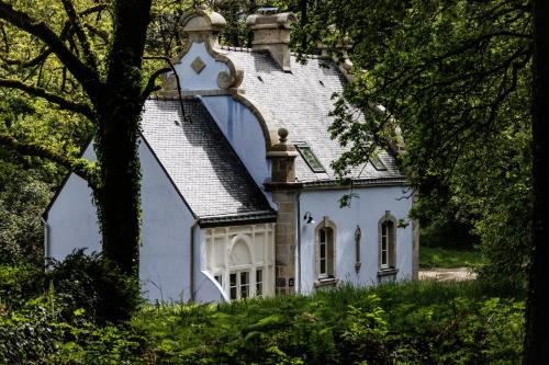 ein weißes Haus mit einem Dach auf einem Hügel in der Unterkunft Domaine de Locguénolé & Spa - Relais & Chateaux in Kervignac