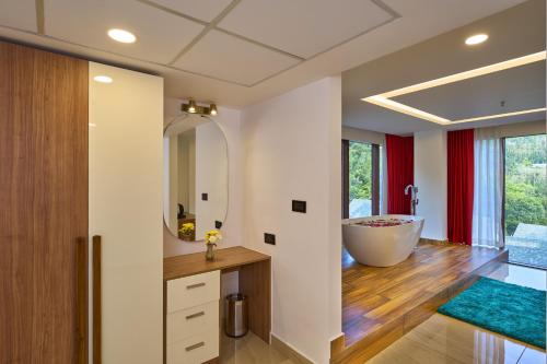 a bathroom with a tub and a large mirror at Serene Horizon in Thekkady