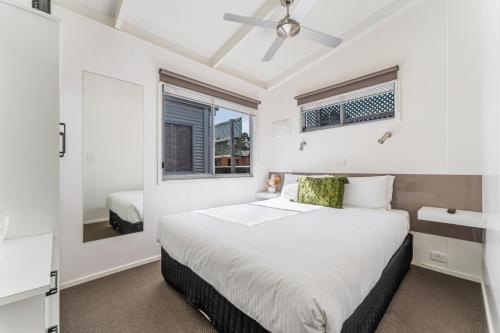 a white bedroom with a bed and a window at BIG4 Tasman Holiday Parks - Warrnambool in Warrnambool