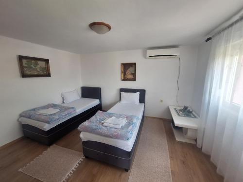 a room with two beds and a sink in it at Apartmani Ruža in Podgorica