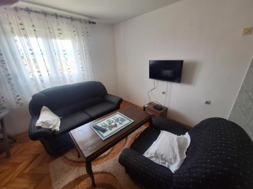 a living room with two chairs and a coffee table at Apartmani Ruža in Podgorica