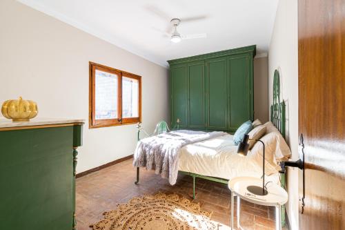 a bedroom with a green headboard and a bed at Cozy house in Priorat! Barbecue & Relax - Climbing & Views in Poboleda