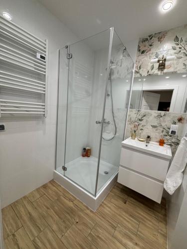 La salle de bains est pourvue d'une douche et d'un lavabo. dans l'établissement Nocleg na doby S 61 ROAD, à Suwałki