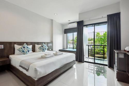 a bedroom with a large bed and a large window at De Piraya residence in Ban Bo Sai Klang