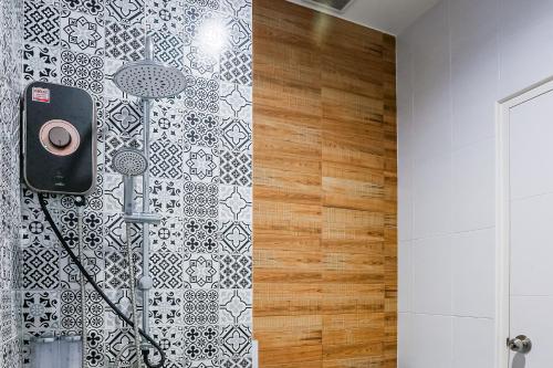 uma casa de banho com um chuveiro e uma parede em azulejo preto e branco. em De Piraya residence em Ban Bo Sai Klang
