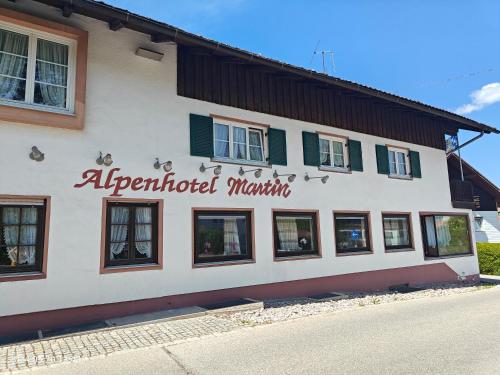 a building with a sign on the side of it at Alpen Hotel Martin in Nesselwang