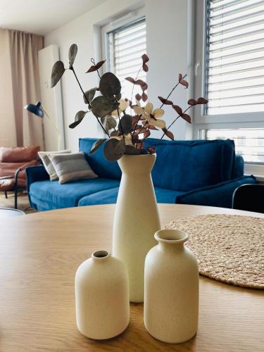 two white vases sitting on top of a table at SmartApartment Prúdy Trnava, Free Parking, 800m CityArena in Trnava