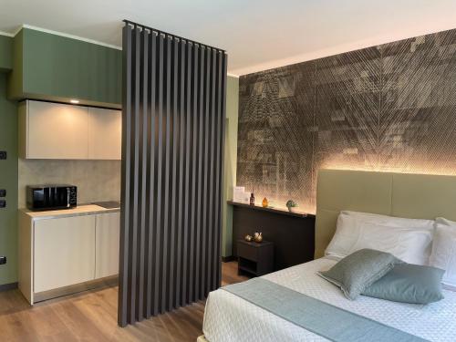 a bedroom with a bed and a kitchen at Casa vacanze Clorofilla in Bergamo