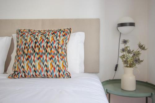 ポルトにあるFormosa79 Apartments by Guestifyのベッド(枕付)、テーブル(ランプ付)