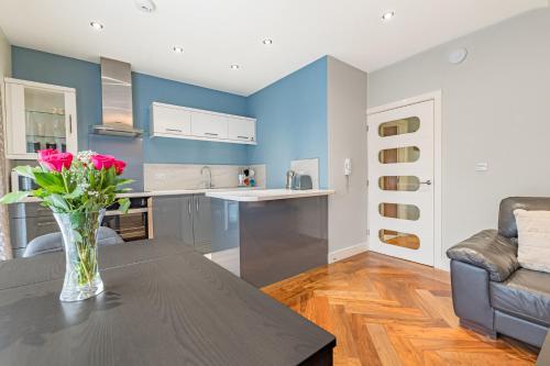 a kitchen with a vase of flowers on a table at Abbey Apartments Modern ApartHotel for Tourists & Professionals in Barrow in Furness