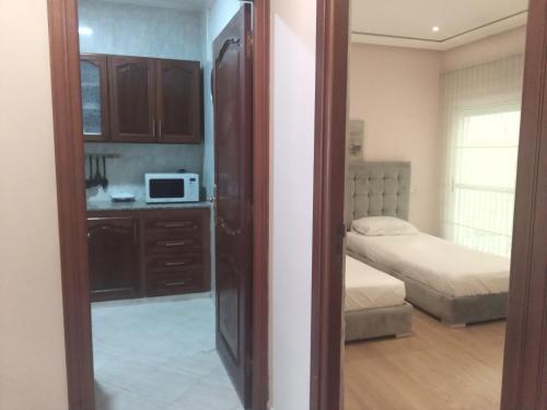 a room with a bedroom with a bed and a microwave at Miramar Martil à 2 min de la plage in Martil