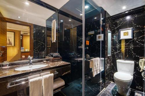 y baño con aseo, lavabo y ducha. en Jinrui Jiatai Hotel Xiamen - Convention and Exhibition Center-Gudishi Subway Station, en Xiamen