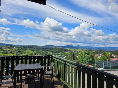 a table and chairs on a balcony with a view at Osrodek Wypoczynkowy Lesniczówka & Elias SPA in Istebna