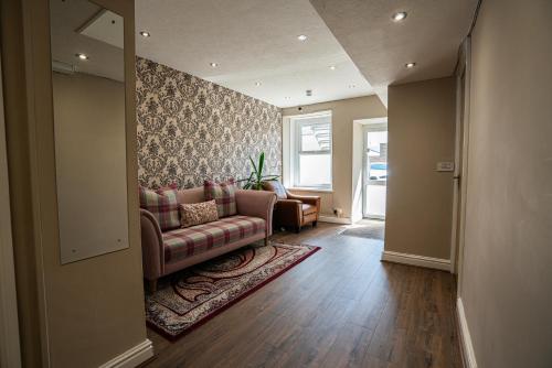 a living room with a couch and chairs and a window at The Central Hotel in Llandudno