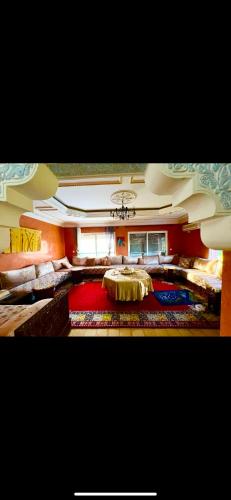 a large living room with a table and a rug at Maison bleue Bouznika in Bouznika