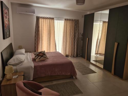 una camera con letto, specchio e sedia di Modern-Studio apartment in Qawra Malta a San Pawl il-Baħar