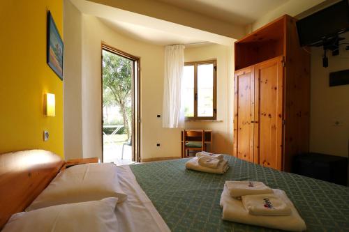 a bedroom with a bed with two towels on it at Nirvana Club Village in Botricello
