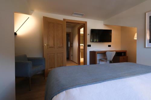 a bedroom with a bed and a desk and a chair at Hotel El Rosal de Cudillero in Cudillero