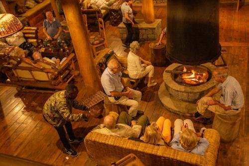 a group of people sitting in a living room with a fireplace at Kivu Paradis Resort in Nyamyumba