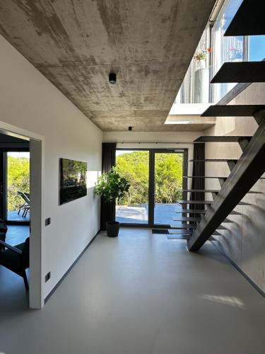 an open living room with a concrete ceiling and stairs at Racers Lodge Grand Prix - mit Hebebühne und Doppelgarage in Bermel