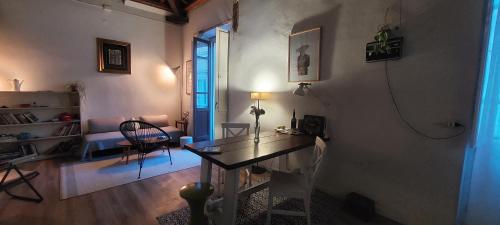 ein Wohnzimmer mit einem Tisch und einem Stuhl in der Unterkunft Bastione home - casa "Vicky" in Cagliari